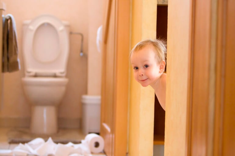 Toddler girl in underwear pulling at toilet roll - Stock Image
